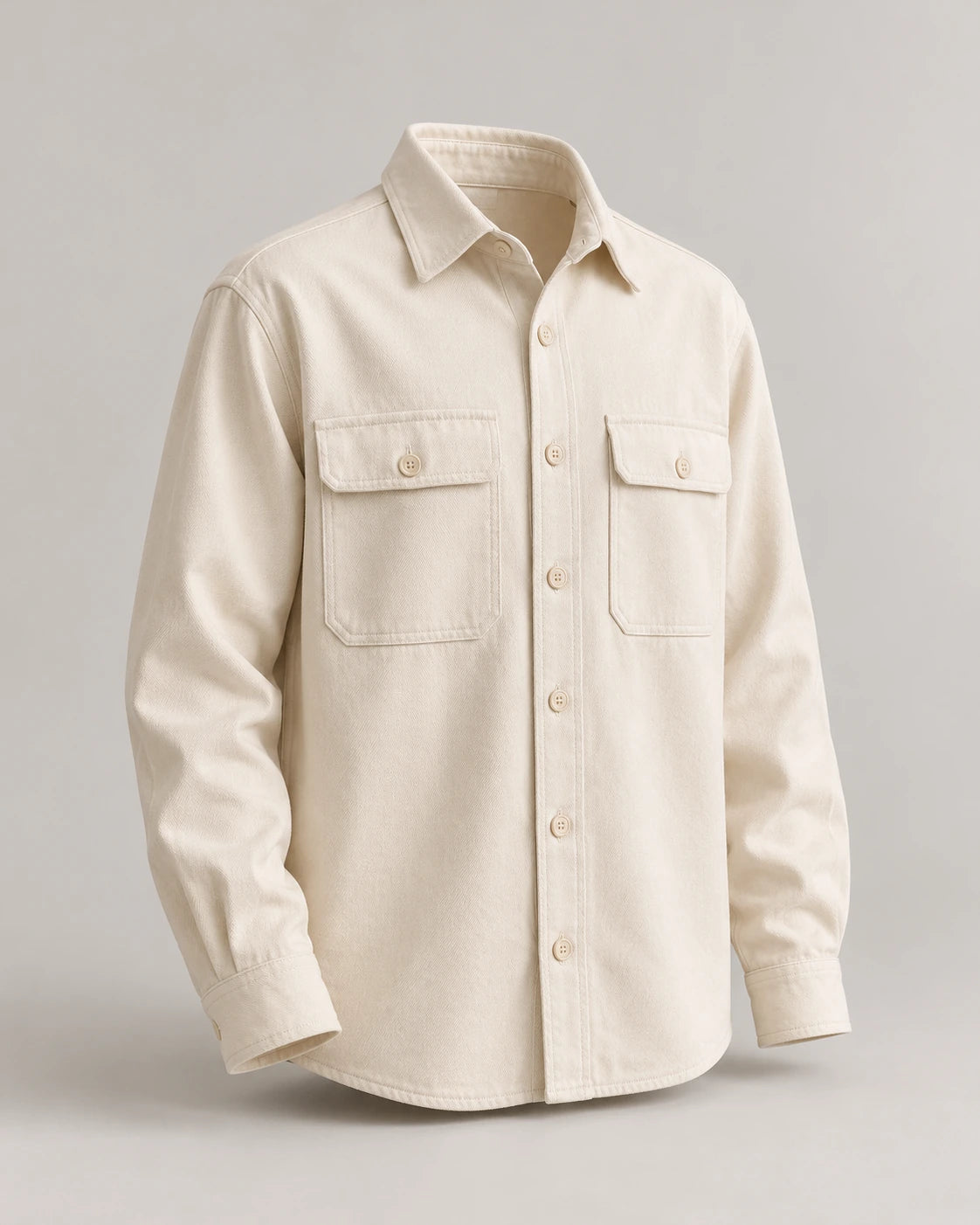 Ecru long-sleeve overshirt with tonal buttons and two chest pockets on a pale studio background.