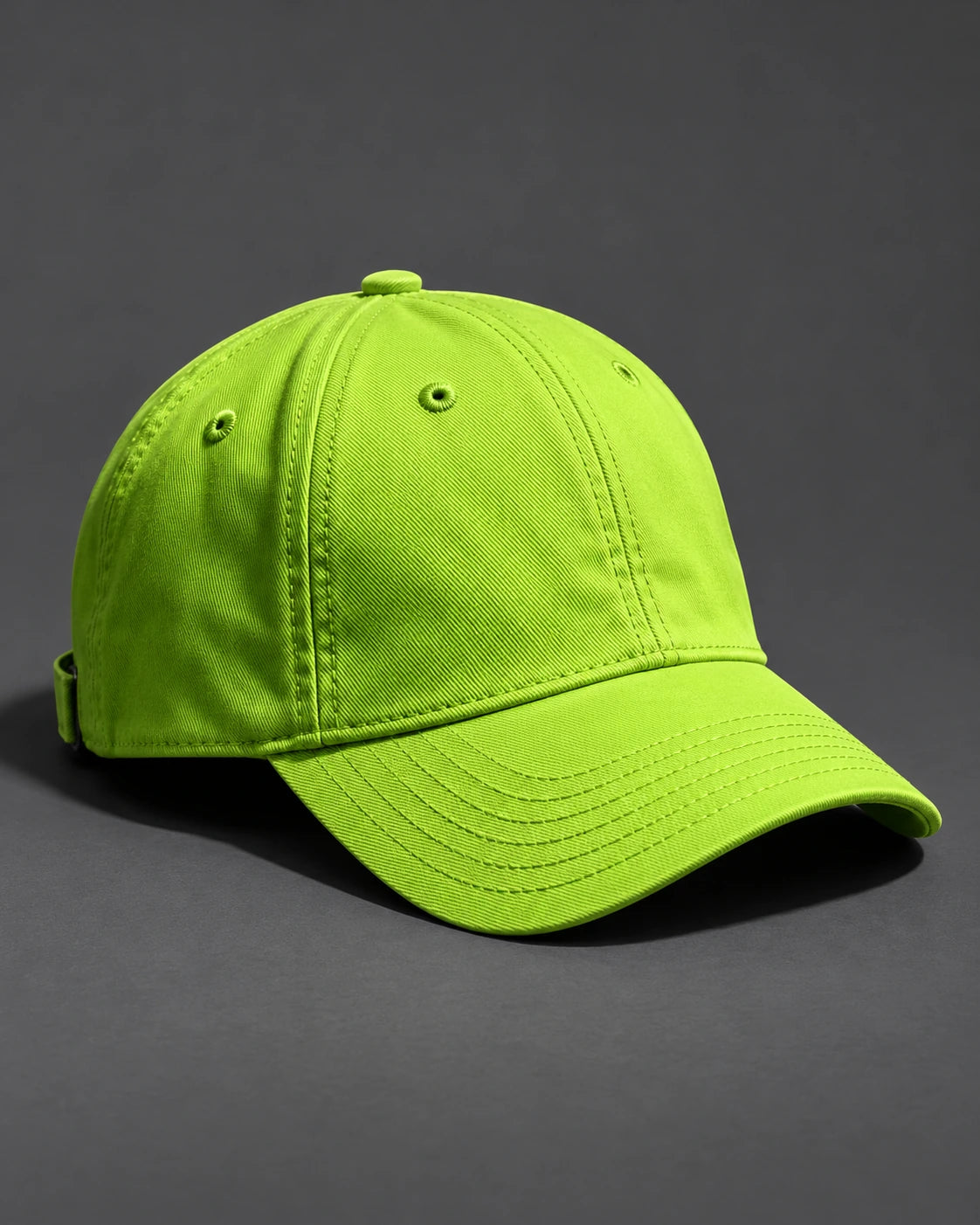 Acid-lime six-panel cap with a curved brim and visible panel stitching on a graphite studio background.
